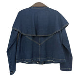 Back of a blue denim jacket with a cape-style overlay and stitched V-shaped yoke