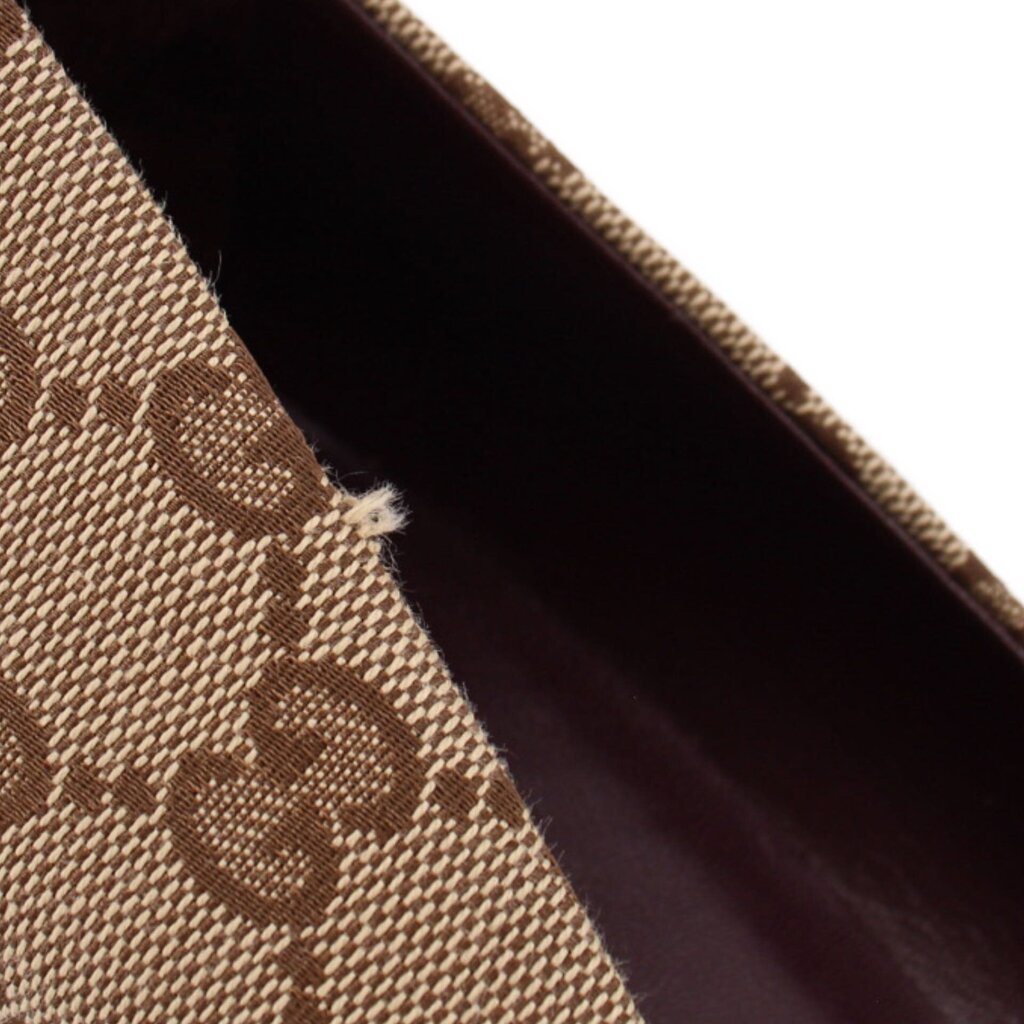 Close-up of GUCCI brown GG monogram pump fabric with a small frayed spot