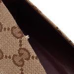 Close-up of GUCCI brown GG monogram pump fabric with a small frayed spot