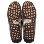 Pair of loafers showing black soles with tan rubber grip studs