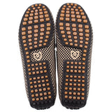 Pair of loafers showing black soles with tan rubber grip studs