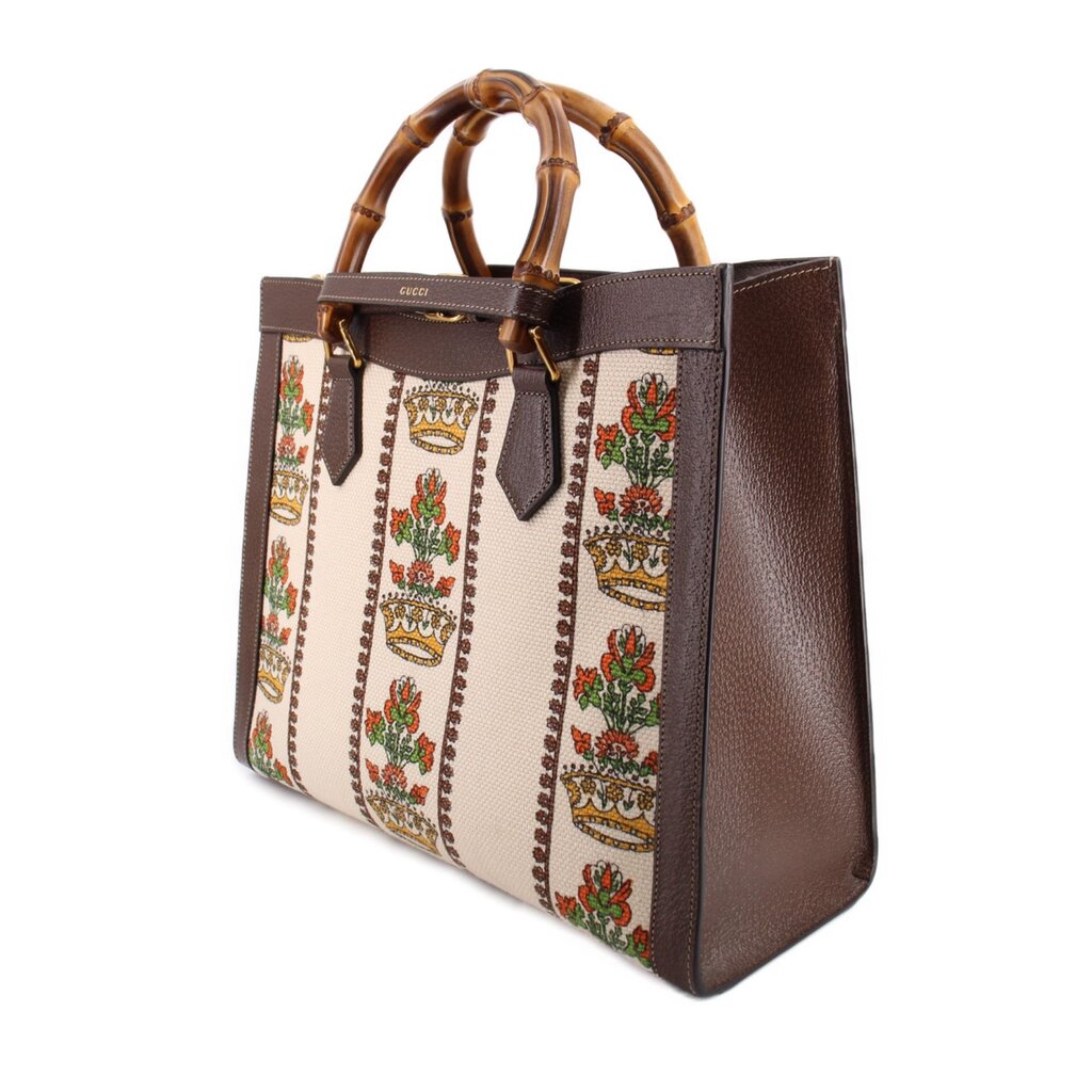GUCCI tote shown from the side, highlighting its brown leather gusset and patterned panels
