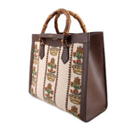 GUCCI tote shown from the side, highlighting its brown leather gusset and patterned panels