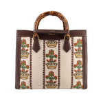 GUCCI tote with cream floral tapestry panels, brown leather trim, and bamboo handles
