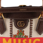 GUCCI tote close-up of gold GG clasp, brown leather trim, and floral fabric