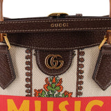 GUCCI tote close-up of gold GG clasp, brown leather trim, and floral fabric