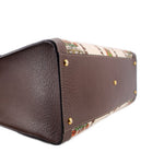GUCCI tote base close-up with textured brown leather and gold protective feet