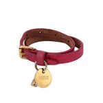 Pink leather wrap bracelet with gold-tone skull charm and branded medallion