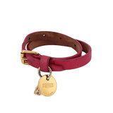 Pink leather wrap bracelet with gold-tone skull charm and branded medallion