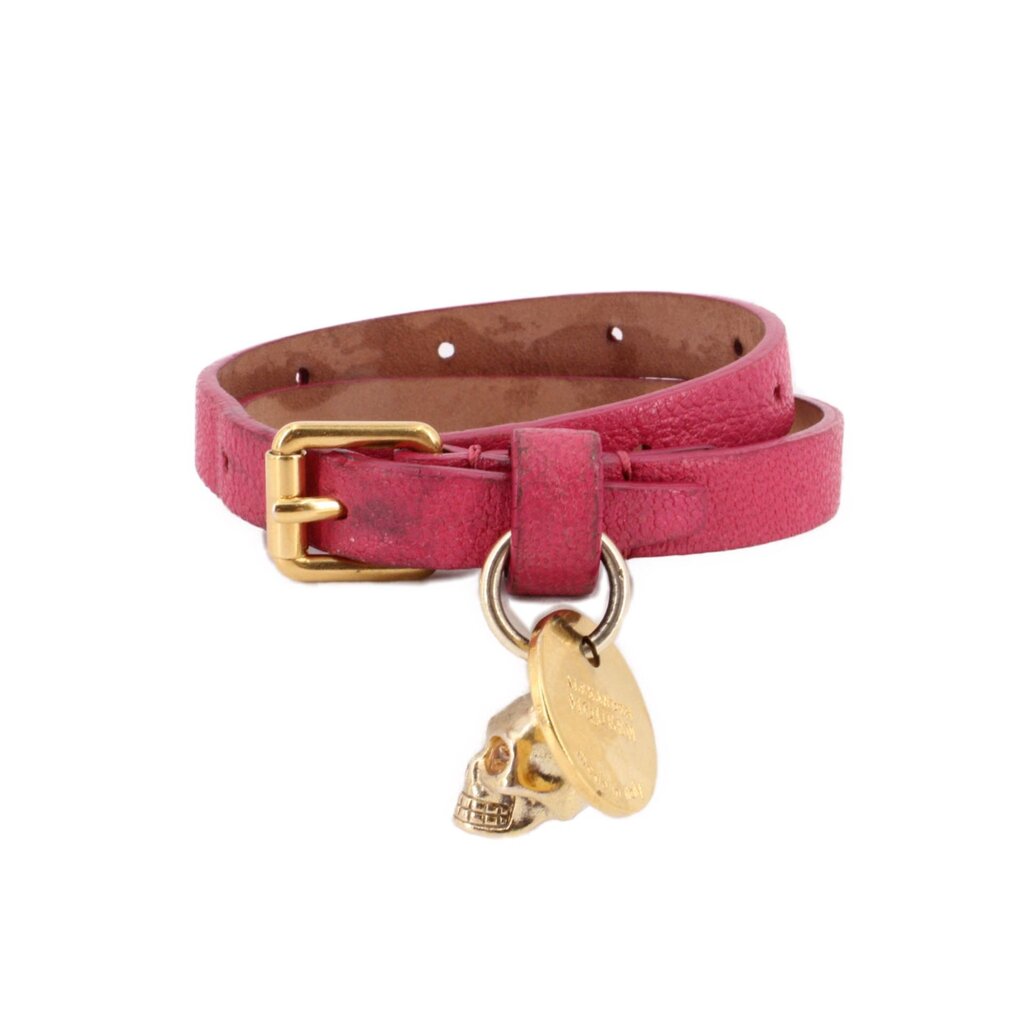 Pink leather bracelet with gold-tone buckle and dangling skull and round medallion charms