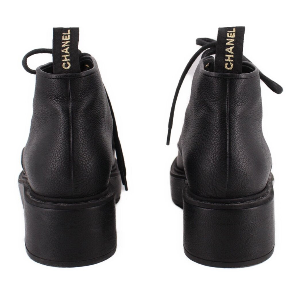 Pair of CHANEL black ankle boots shown from the back, with pull tabs and platform heels
