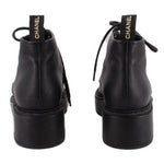 Pair of CHANEL black ankle boots shown from the back, with pull tabs and platform heels