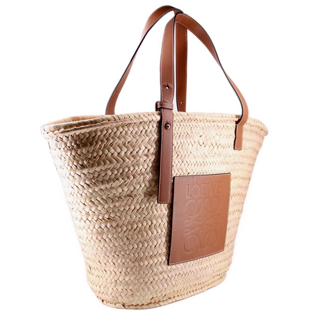 LOEWE woven palm-leaf tote, angled view showing brown leather handles and logo patch