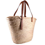 LOEWE palm-leaf tote shown from the side, with brown leather handles