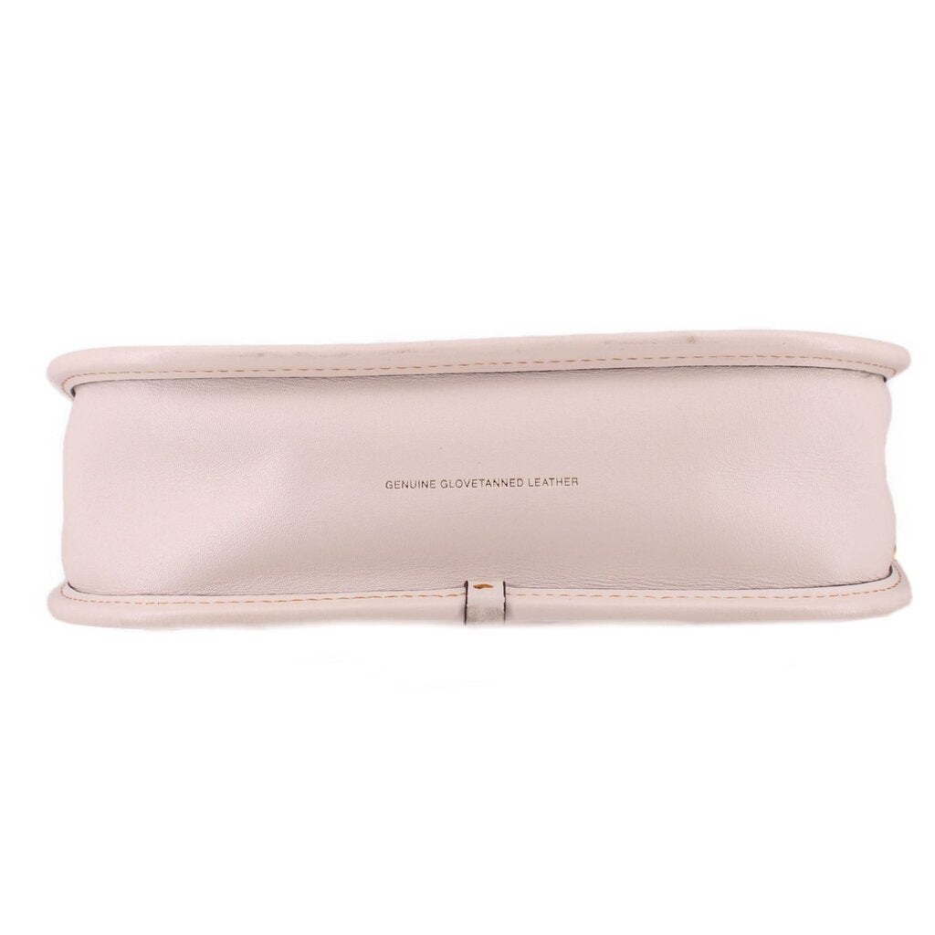 Bottom of the cream COACH Swinger leather bag with a centered leather stamp