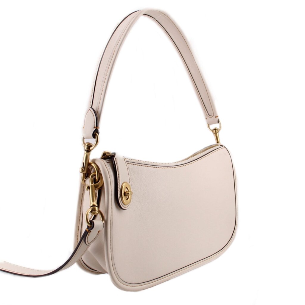 COACH Swinger cream leather bag shown at an angle with detachable crossbody strap