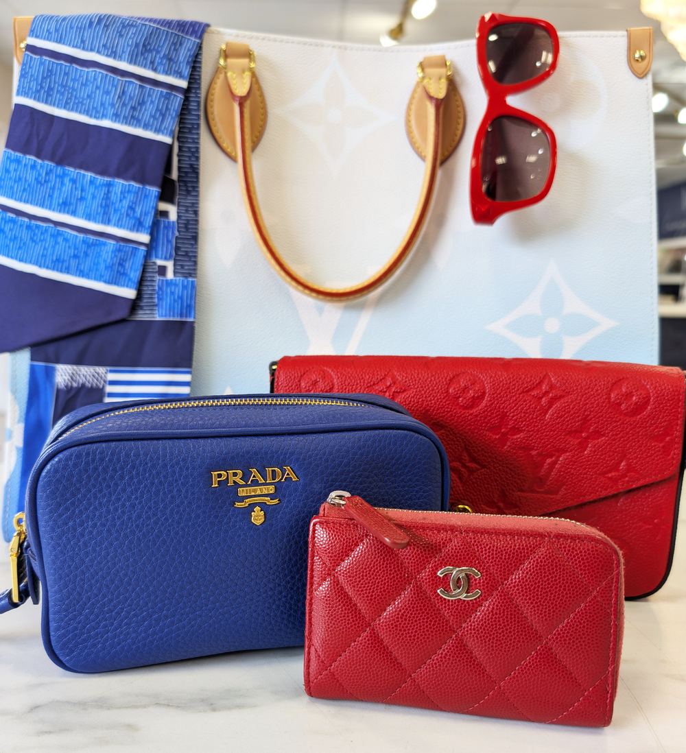 A collection of red, white, and blue handbags, along with a pair of sunglasses and a scarf.