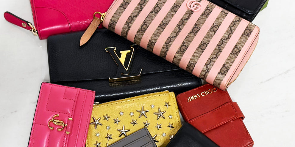 A collection of luxury designer wallets on a white background.