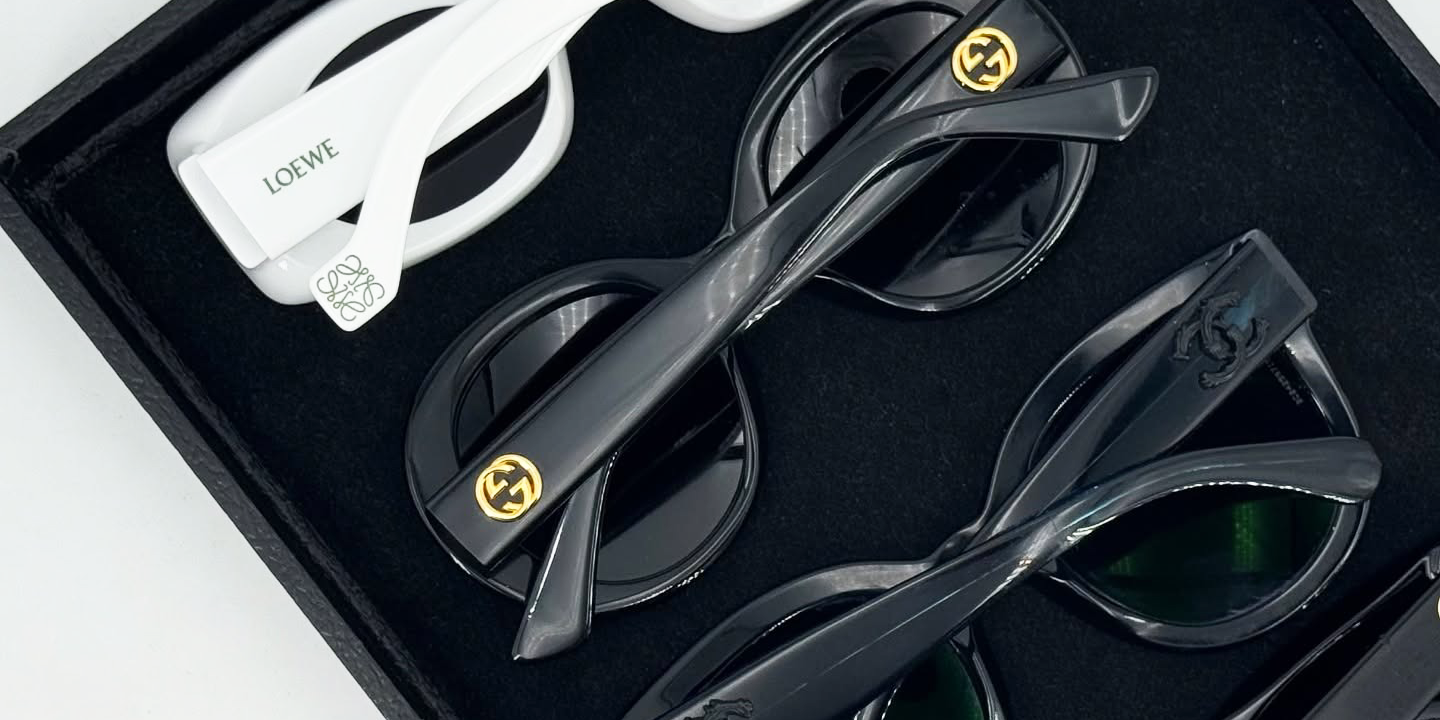 A collection of sunglasses in a black tray.