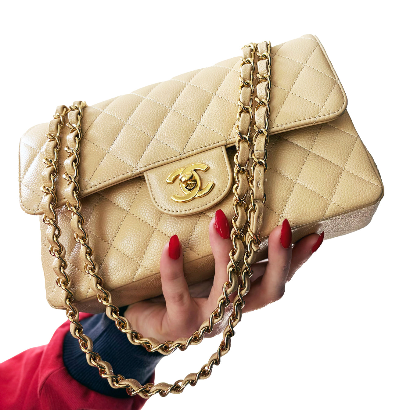 A beige quilted Chanel handbag being held by a woman's hand with red nails.
