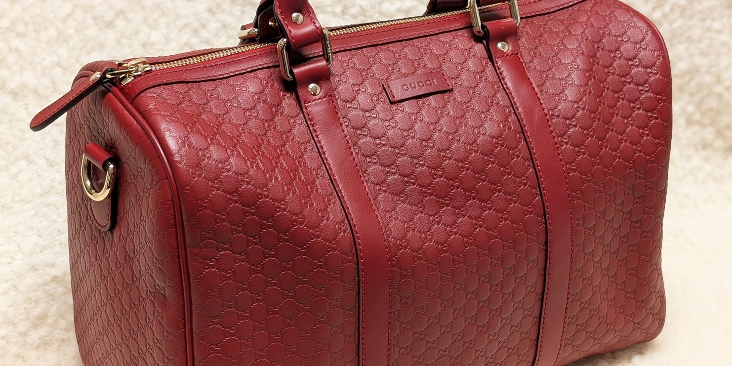 Red Gucci Boston Joy handbag on a cream shearling background.