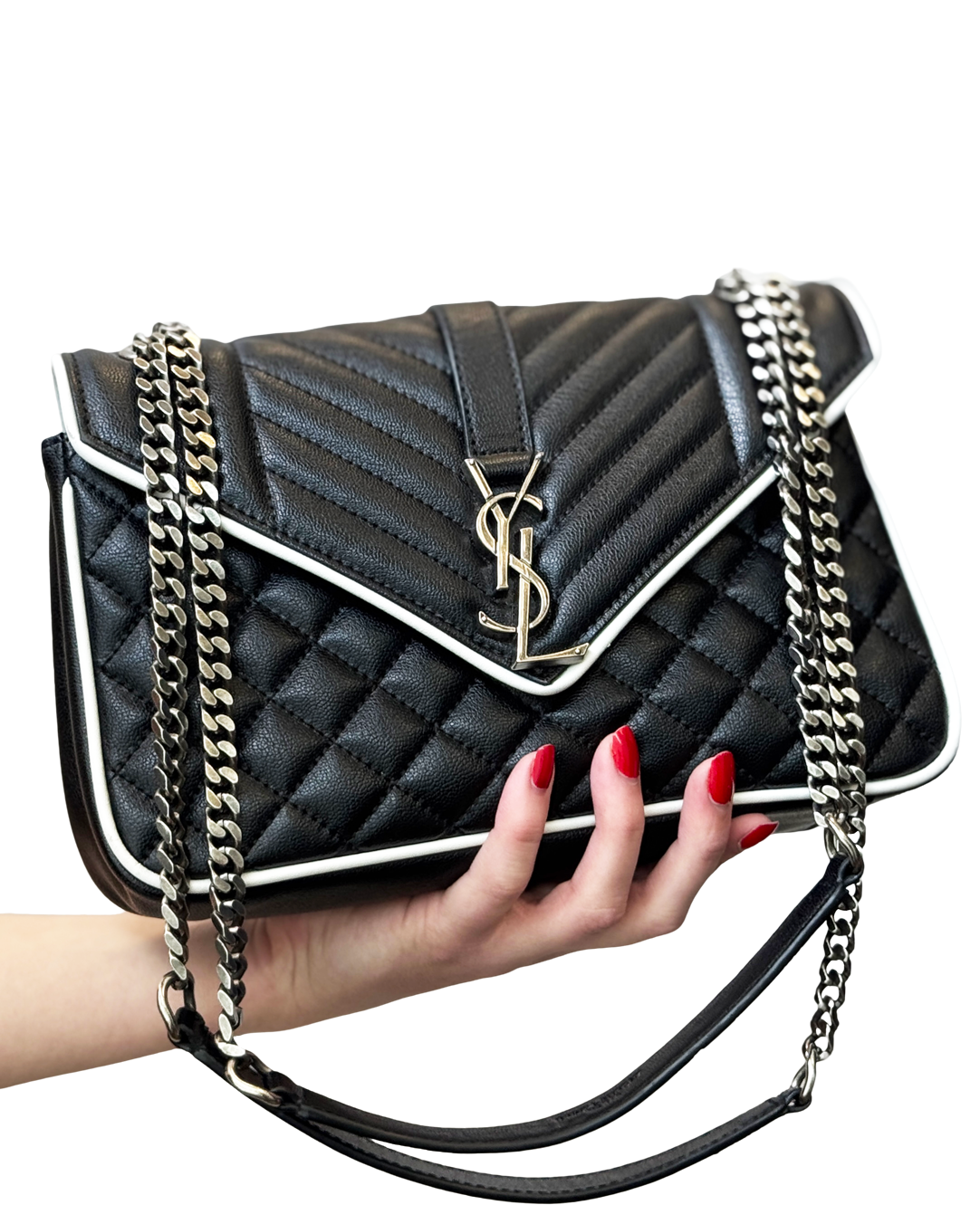 Black quilted Saint Laurent handbag with white trim being held by a woman with red nails.