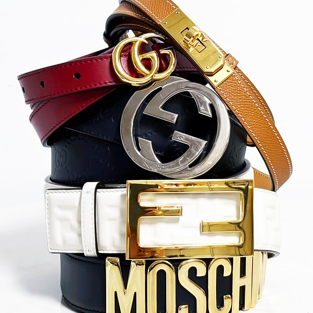 A stack of designer belts on a white background.