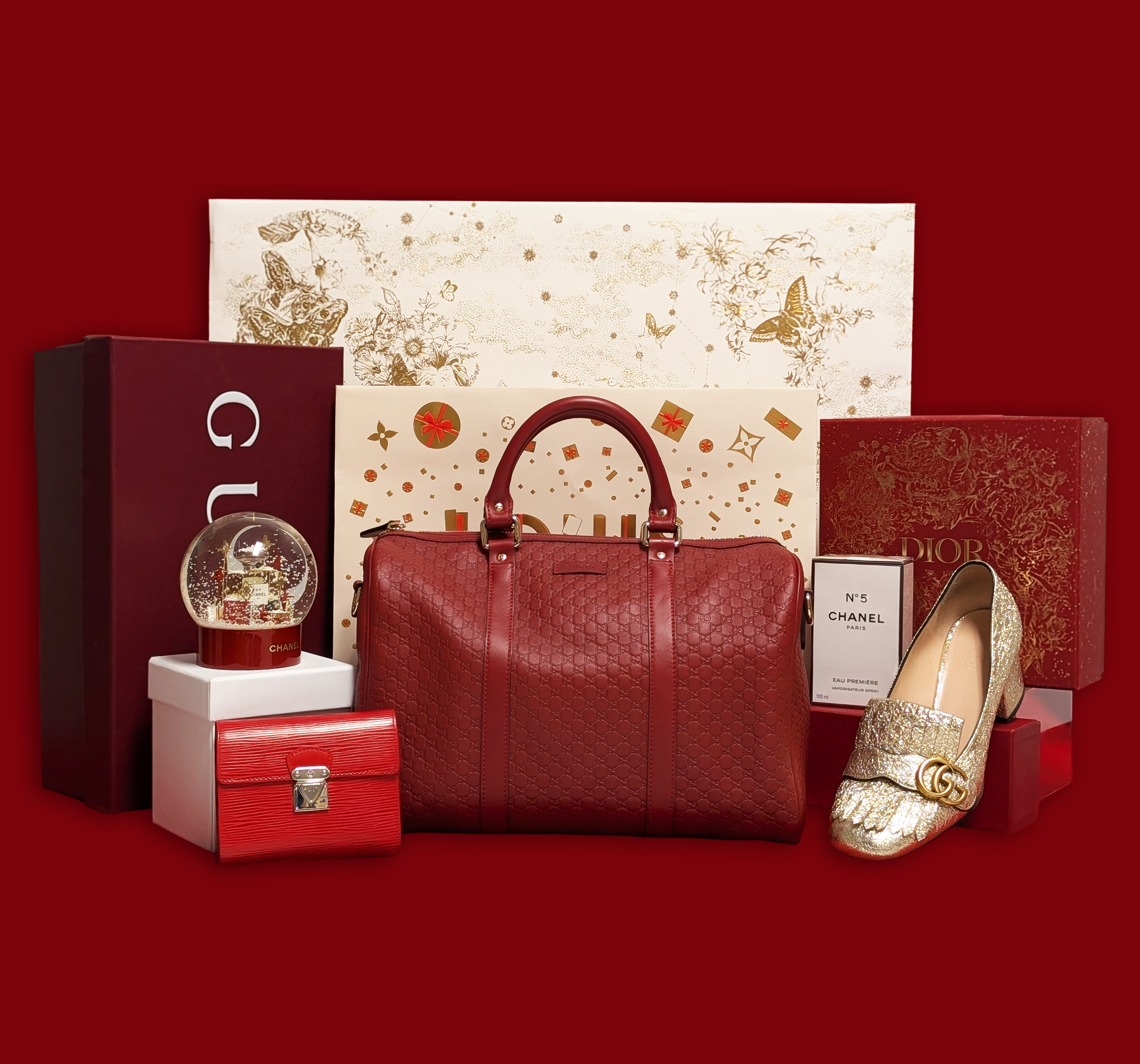 A photo of holiday-themed designer shopping bags behind Gucci, Chanel, and Louis Vuitton product.