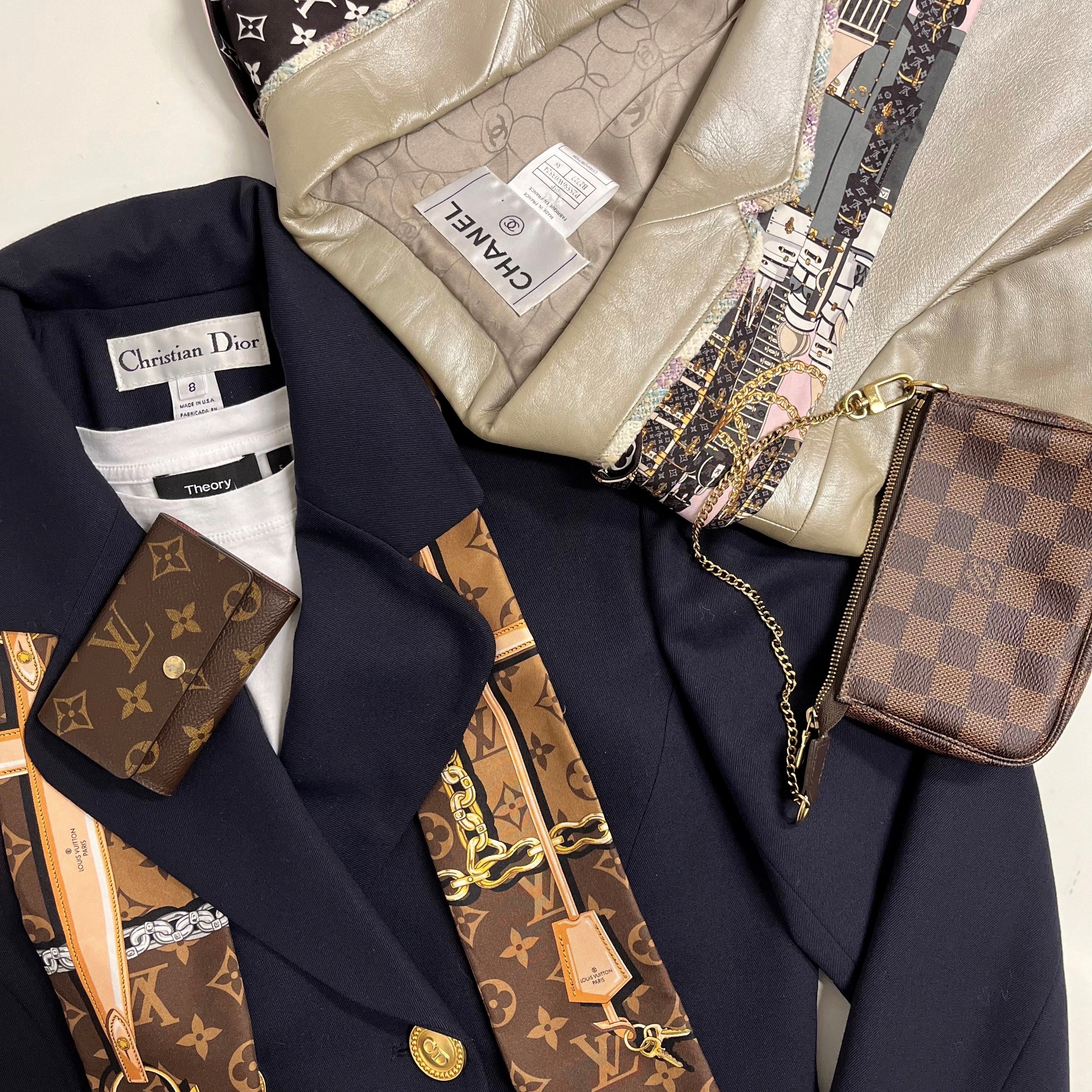 A photo of two designer blazers with scarves and wallet accessories.